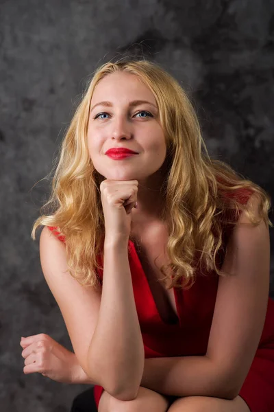 Retrato Uma Jovem Mulher Vestido Vermelho Mão Queixo Sobre Fundo — Fotografia de Stock