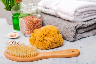 Spa aksesuarları, fırça, tuz, yağ, havlular beyaz bir masa üzerinde
