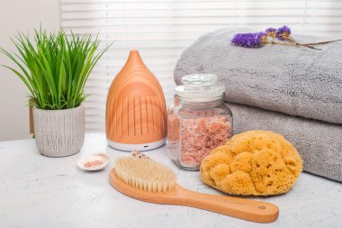 Spa aksesuarları, fırça, tuz, yağ, havlular beyaz bir masa üzerinde