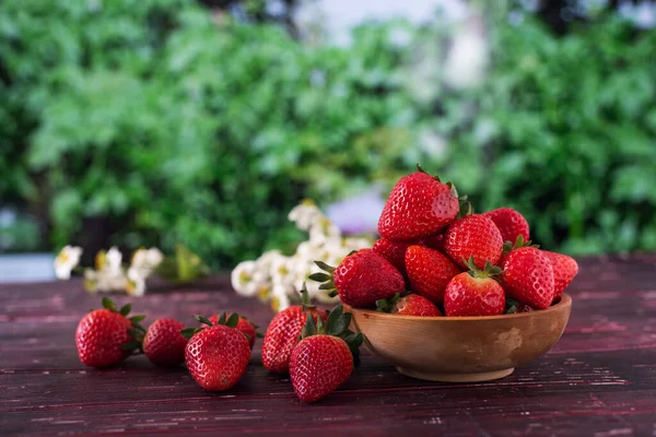 成熟的草莓放在花园里桌子上的木杯里 — 图库照片