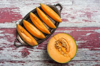 Olgun sarı kavun, yarısı ve parçaları bir bıçakla. Yukarıdan görüntüle