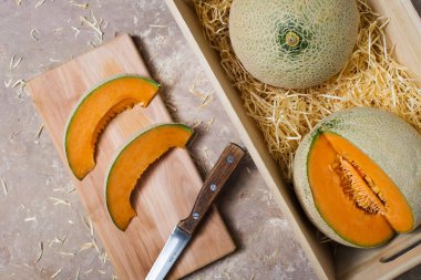 Karpuzlar samandaki ahşap bir kutuda. Tahtasında bıçak olan kavun parçaları..