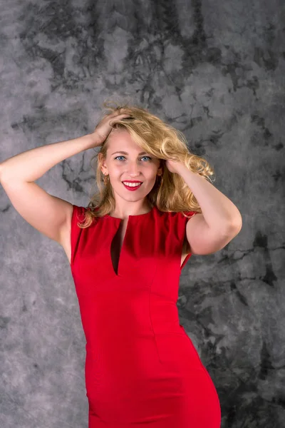 Blond Woman Red Dress Smiles Touches Hair Hands — Stock Photo, Image