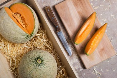 Karpuzlar samandaki ahşap bir kutuda. Tahtasında bıçak olan kavun parçaları..