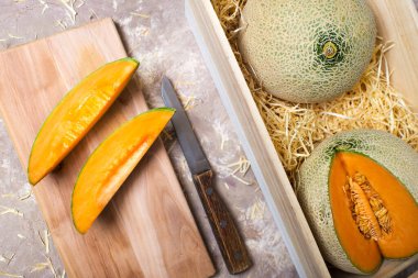 Karpuzlar samandaki ahşap bir kutuda. Tahtasında bıçak olan kavun parçaları..