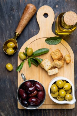 Kesme tahtasında zeytin ve zeytin yağı. Yukarıdan görünüm.