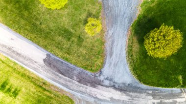 Nisan ayının güneşli bir gününde yürüyüş yolları olan parkın en üst manzarası, yerdeki gölgelerin yansıması. Drone fotoğrafçılığı