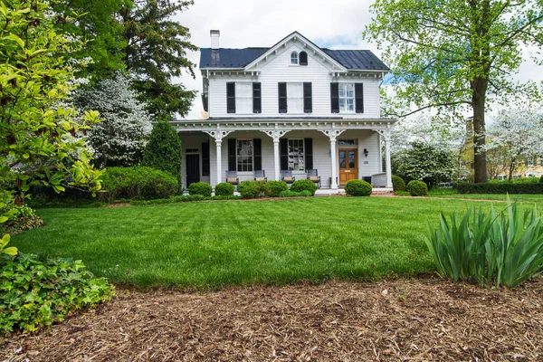 two-story wooden American house with brick steps with white columns in leesburg, virginia, usa,