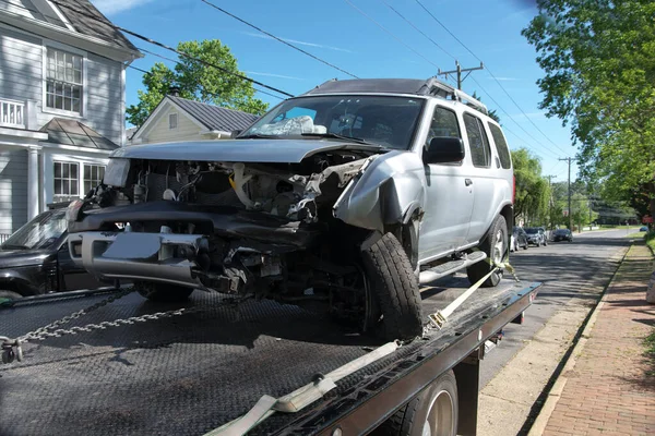 Loading broken car on a tow truck. Damage vehicle after crash accident on the highway road.