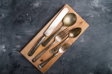 Eski mutfak aletleri. Çatallar, bıçaklar, kaşıklar ve kesme tahtası. Yukarıdan görüntüle