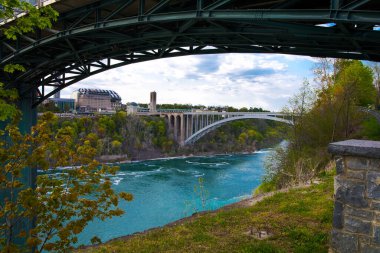 Niagara Şelalesi. - New York. ABD. 16 Mayıs 'ta. 2021 yılı. Niagara Şelalesi yakınlarındaki Gökkuşağı Köprüsü 'nün panoramik manzarası Amerika ile Kanada sınırında.