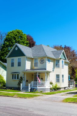 Watkins Glen, New York, ABD 19 Mayıs 2021 Ulusal bayrağı ve ön cephesinde bir yıldızı olan geleneksel iki katlı beyaz Amerikan evi..