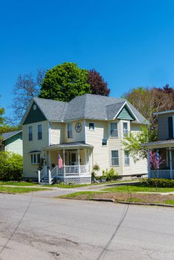 Watkins Glen, New York, ABD 19 Mayıs 2021 Ulusal bayrağı ve ön cephesinde bir yıldızı olan geleneksel iki katlı beyaz Amerikan evi..