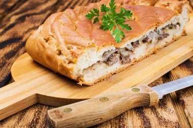 Tahta bir masada taze pişmiş etli turta.