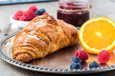 delicious breakfast with croissants, orange and raspberry jam