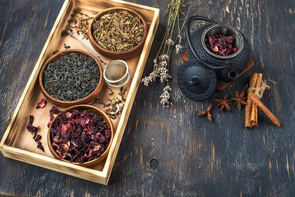 在木制碗中的各种干茶和在木制表面的茶壶 茶道用的 — 图库照片