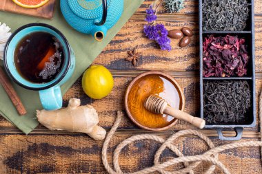 Farklı çay türleri (siyah, yeşil, amber çiçeği, bitki) ahşap bir masanın üzerindeki ahşap kaselerde. Yukarıdan görüntüle