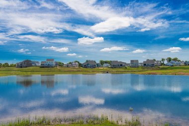 Şehrin kenar mahallelerinde büyük gölü olan standart yeni binaların ikamet yeri. Evlerin mavi sularındaki yansıma ve mavi gökyüzü