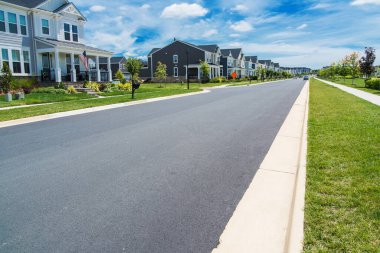 Leesburg, Virginia 'da mahalle sokağı ve asfalt yol modern konut manzaralı. Güneşli bir gün, hızla büyüyen şehir hayatı.