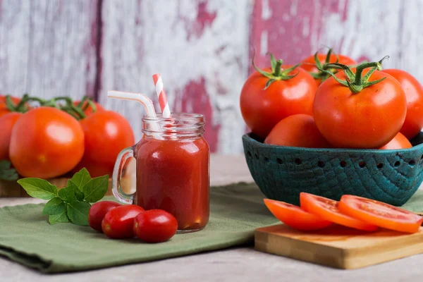 テーブルの上のボウルにトマトジュースを入れます まな板の上のトマトのみじん切り — ストック写真