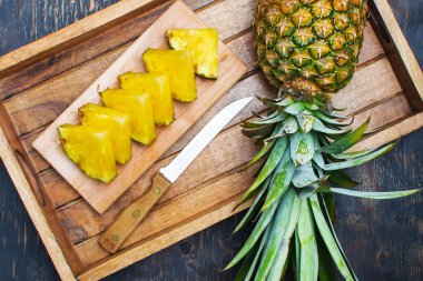 Kesme tahtasında ananas ve ananas dilimleri..