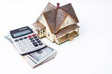  Ev, banknotlar ve finansal hesaplamalar için bir hesap makinesi üzerine kuruludur. Beyaz arkaplanda izole.