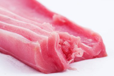 Beyaz arka planda çiğ ton balıklı bifteğin yakın görüntüsü.