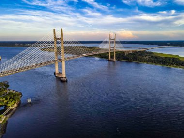Jacksonville Köprüsü 'nün manzaralı manzarası altın ışık altında. Çelik, gökyüzü ve kıyı zarafetinin bir karışımı..