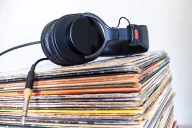 Beyaz arka planda klasik vinil albüm ve kulaklıkların yakın plan görüntüleri
