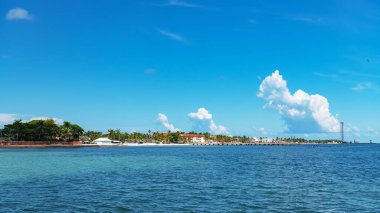 Bulutlu mavi gökyüzü olan tropikal Florida adasında okyanus manzaralı evler