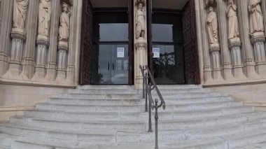 Washington Ulusal Katedrali 'nin girişindeki detaylı taş heykeller, gotik portal manzaralı. İnsansız hava aracı yükseliyor.