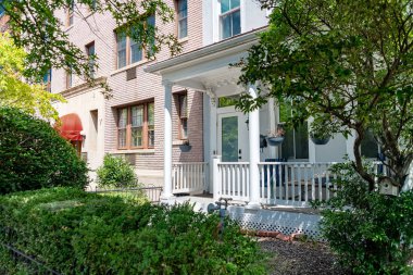 Klasik bir DC evinin dışında iyi bakılmış bir bahçe. Güneşli bir günde mimari ve doğal güzellikler ön plana çıkıyor.