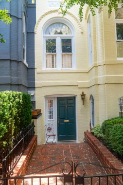 Ağaçlar ve mevsimlik yapraklar çerçeveli büyüleyici bir mesken girişi.