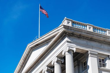 Washington 'da sütunları ve vatansever bayrağı olan tarihi Amerikan tarihi simgesi üzerinde parlak mavi bir gökyüzü.