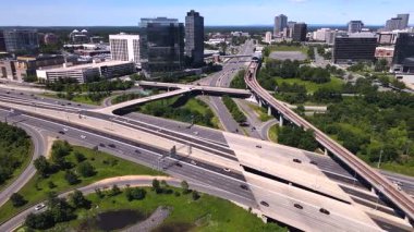 Gökdelenleri ve peyzajı olan modern bir şehirde ekspres yol ve yükseltilmiş bir otoyol manzarası.