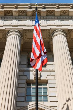 Washington 'da sütunları olan hükümet binasının önündeki Amerikan bayrağı. Aşağıdan görüntüle.