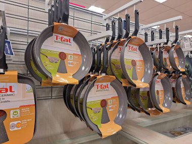 Mutfak gereçleri perakende reyonunda seramik ve yapışmaz yemek takımı asılı.