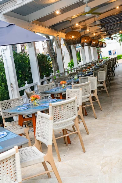 Boş masaları ve zarif masaları olan açık hava restoran terası.