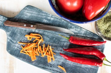 Kırsal kesim tahtasında bıçak ve otlarla dolu renkli taze sebzeler.