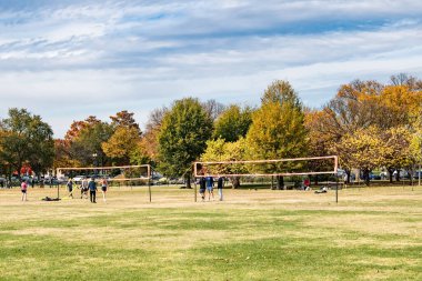 Arka planda Washington Anıtı olan Ulusal AVM 'nin çimlerinde voleybol ve spor aktiviteleri
