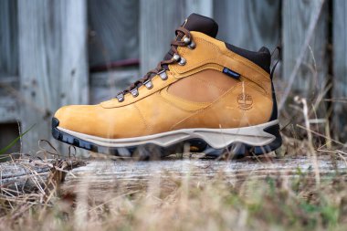 Timberland sarı deri yürüyüş botları. Doğal çimenlikte açık ayakkabılar.