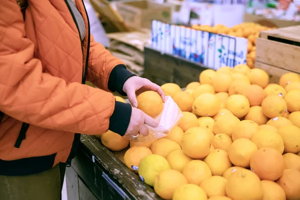 Süpermarketten taze meyve ve portakal seçen müşteri elleri
