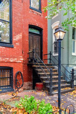 Demirden korkuluklar ve sonbahar yapraklarıyla tarihi şehir evi basamakları