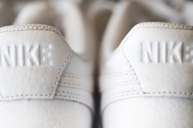 Nike logosunu kapatın. Beyaz deri ayakkabılarla kabartma makro fotoğrafçılık.