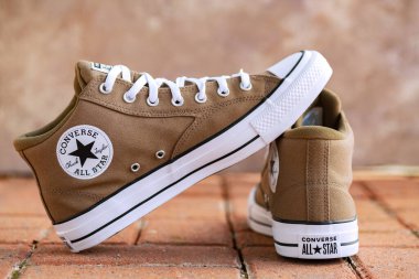 Kahverengi Converse All Star spor ayakkabıları tuğla arka planda gündelik ayakkabı moda konsepti