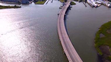 Körfezin karşısındaki Chincoteague kasabası ve Assateague Doğa Koruma Alanı 'na giden yol. Yol ve arabaların hava manzarası