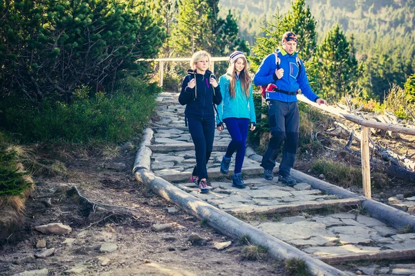 Ouders met dochter wandelaars trektochten in de bergen. — Stockfoto