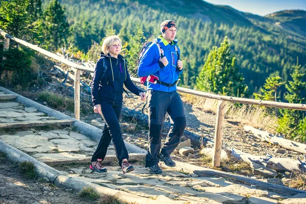 Man en vrouw wandelaars trektochten in de bergen. — Stockfoto