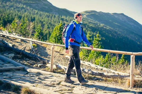 Man wandelaar trektochten in de bergen — Stockfoto