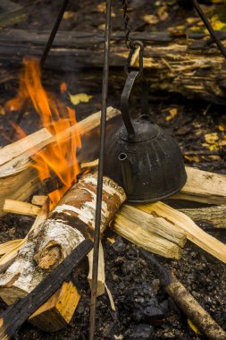 Eski kirli çaydanlığa yakın çekim. Su turistik kampta ateşte sallanıyor ve ısınıyor.